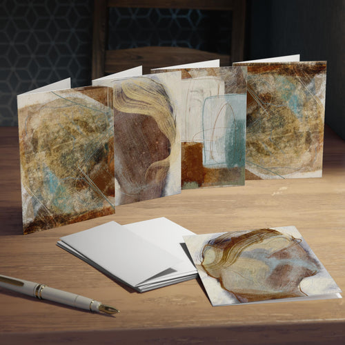 Set of greeting cards with artistic designs on a wooden surface