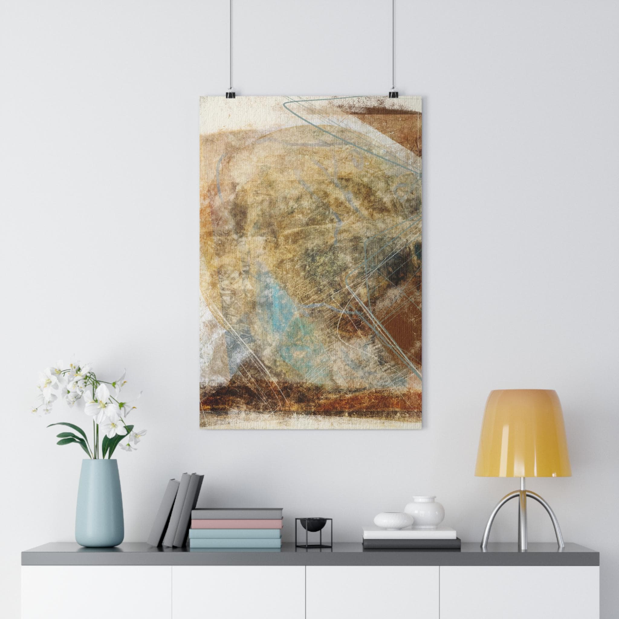Abstract art print on a wall above a white cabinet with decor items.