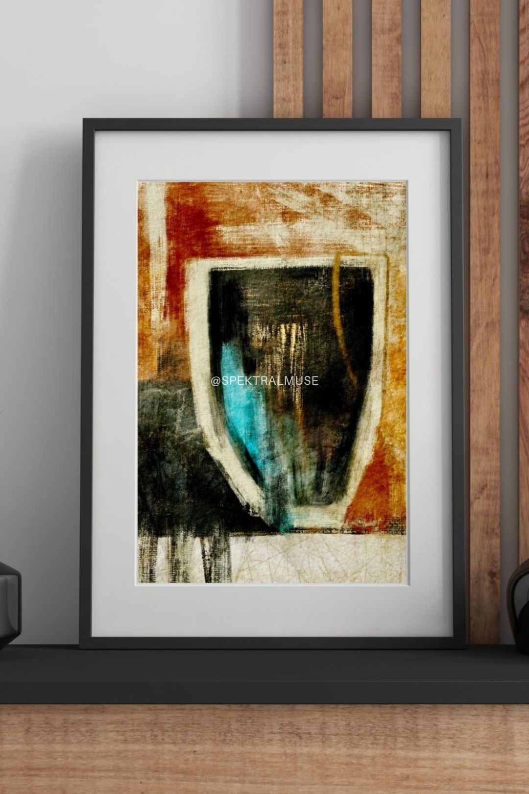 Framed abstract art print on a wall with wooden paneling.