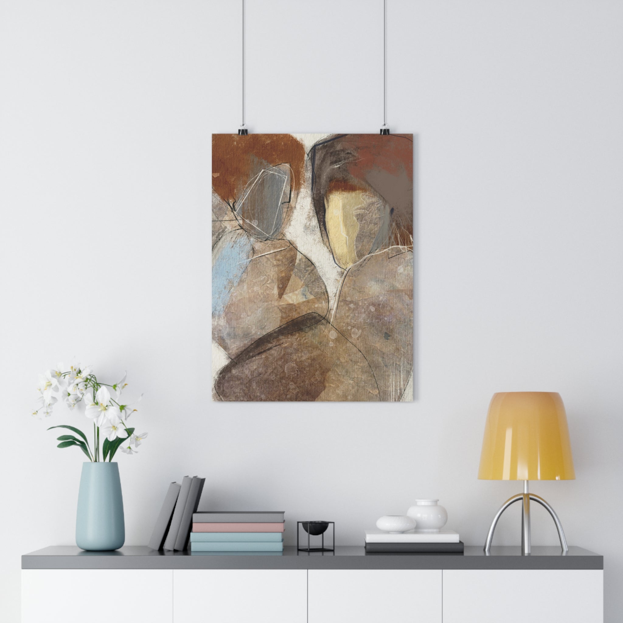 Abstract painting hanging on a white wall above a shelf with decor items.
